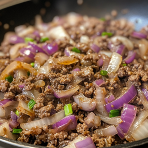 Juicy ground venison patties cooking on a grill with fresh herbs and vegetables.